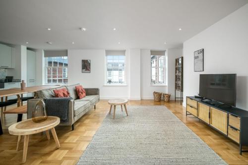 a living room with a couch and a tv at Stunning flat near Holland Park in London