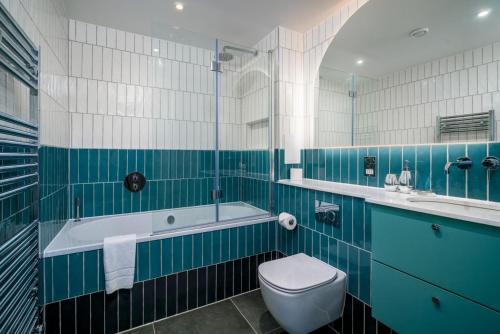 a bathroom with a tub and a toilet and a sink at Stunning flat near Holland Park in London