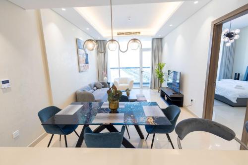 a dining room and living room with a table and chairs at Chic & Bright 1BR Lagoon Suite in Gateway II in Ras al Khaimah