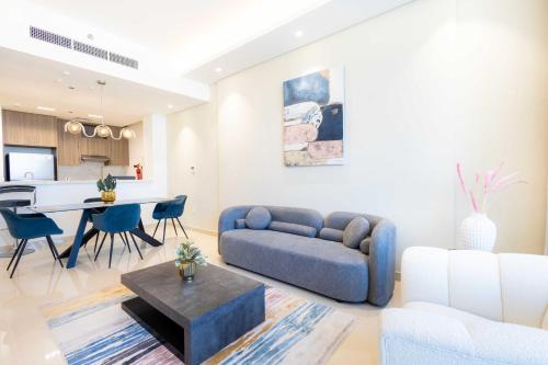 a living room with a couch and a table at Chic & Bright 1BR Lagoon Suite in Gateway II in Ras al Khaimah