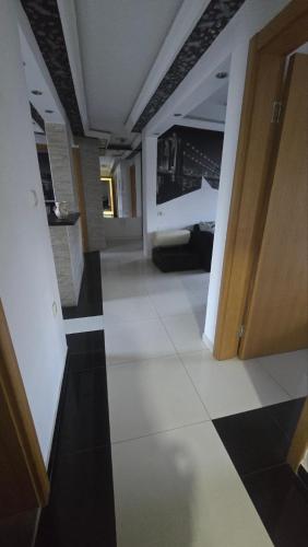 a room with a hallway with black and white tile at Tvrdjava Apartman in Petrovaradin