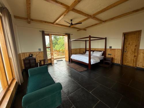 The Meemos Cafe And Cottages في تشاكراتا: غرفة نوم بها سرير وأريكة في الغرفة