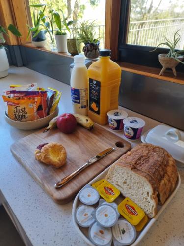 パッケナムにあるQueen Room with Balcony - Kookaburra Retreat Homestayのまな板とパンと卵が置かれたテーブル