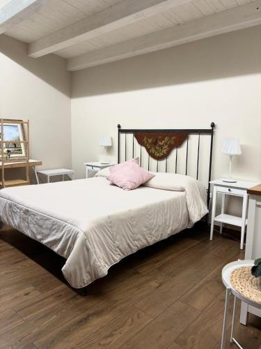 a bedroom with a large bed with a pink pillow at Borgo Nocchiara in Carlentini