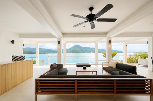 ein Wohnzimmer mit einer Couch und einem Deckenventilator in der Unterkunft Villa Nevaeh - Ocean Front Private Villa Kamala Beach in Phuket