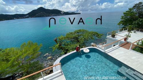 eine Person, die neben einem Pool neben dem Wasser steht in der Unterkunft Villa Nevaeh - Ocean Front Private Villa Kamala Beach in Phuket