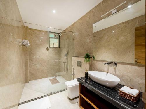 a bathroom with a sink and a shower and a toilet at The Infinity Pool Villa Hotel by DanCenter, Baga Beach, Goa in Arpora