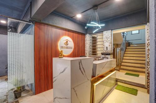 a room with a staircase and a kitchen with a counter at Hotel Orchard Nest - Pune Sinhgad Road in Pune