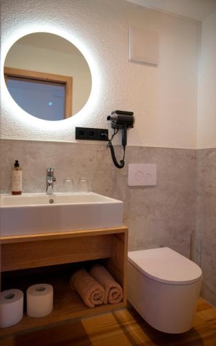 a bathroom with a sink and a toilet and a mirror at Weinstube Sinas Brettl in Nördlingen