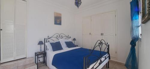 a bedroom with a bed with blue and white sheets at Riad Diaz Taghazout in Taghazout