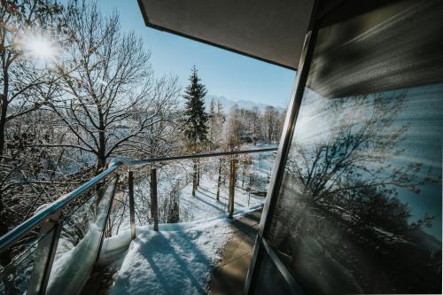 a room with a balcony with snow on the trees at VisitZakopane - Cristal Apartment in Zakopane