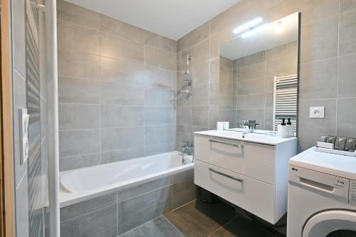 大博尔南Appartement Le Barat'ski的带浴缸、水槽和浴缸的浴室