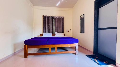 una camera da letto con un letto blu in una stanza di Samarth Beach Resort a Malwan