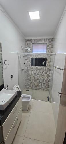 a bathroom with a shower and a toilet and a sink at Casa próximo ao lago - 1 in Boa Esperança
