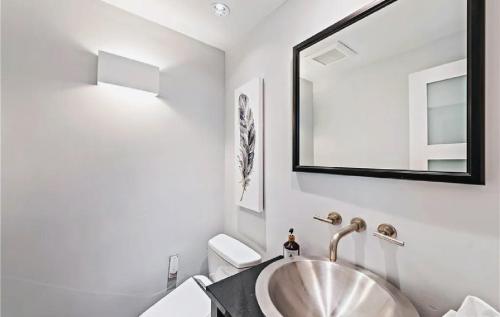 un baño con lavabo y espejo en Luxury Three-Bedroom Oceanfront Residence With Panoramic Coastal Views, en Laguna Beach
