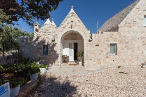 a stone house with a courtyard in front of it at Marinella Suite Home in Locorotondo