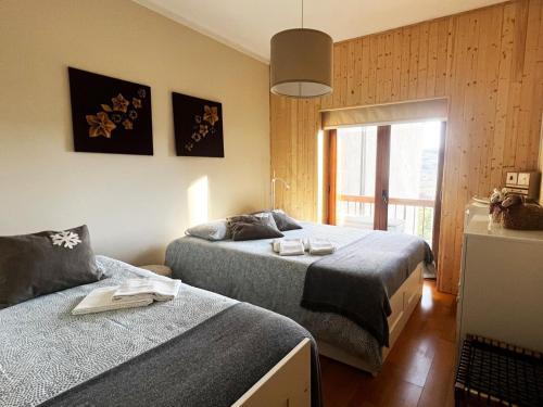 a bedroom with two beds and a window at Casa da Serra - T1 - Penhas da Saúde in Penhas da Saúde