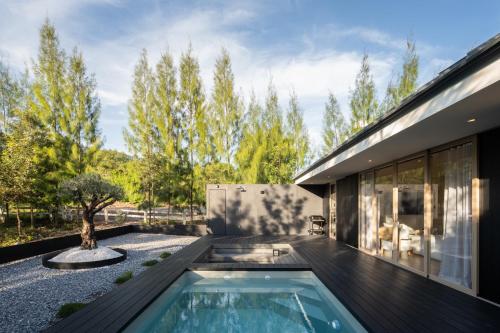 a backyard with a swimming pool and a house at Kuro Pool Villa Khaoyai in Ban Wang Sai