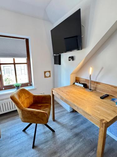 a living room with a wooden table and a chair at SmartStay Hotel Pumpengasse in Wolfsburg