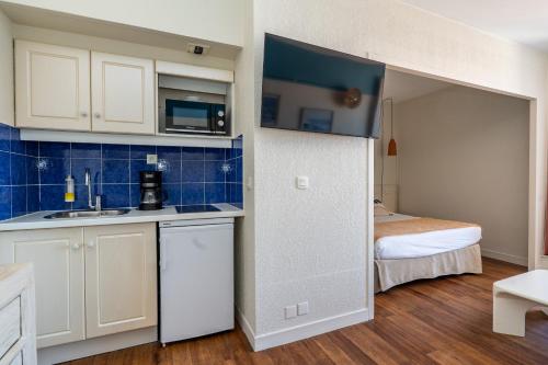 a kitchen with a sink and a bed in a room at Résidence Vacances Bleues Le Grand Large in Biarritz