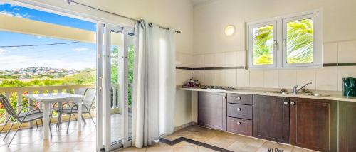 een keuken met een balkon met een tafel en stoelen bij Wayaca Mini Resort in Willemstad