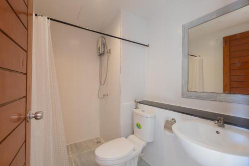 Un baño con inodoro, lavabo y espejo. en Baan KetKaew Patong, en Patong Beach