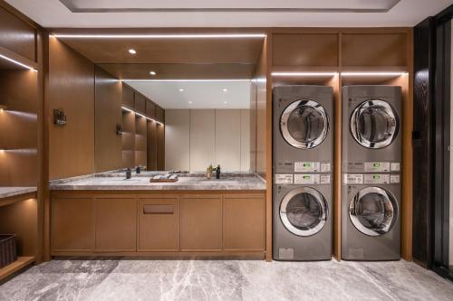 HaihuiにあるGuanyun Manxin Mansion, Guling, Lushanのバスルーム(洗濯機3台、シンク付)