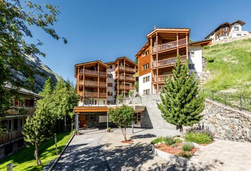 an apartment building with trees in front of it at Ari Resort Apartments in Zermatt