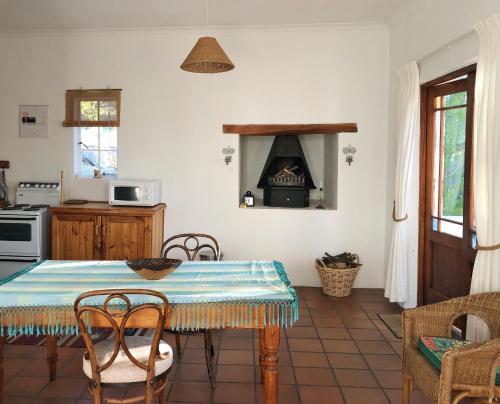 a kitchen with a table and an oven in a room at Eensgevonden Vineyard Cottages in Rawsonville