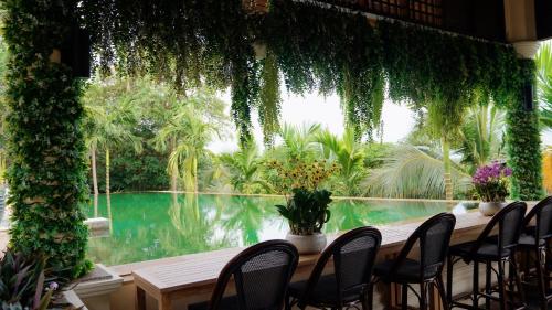 a room with a table and chairs and a swimming pool at 普吉高端康养泳池别墅 in Layan Beach