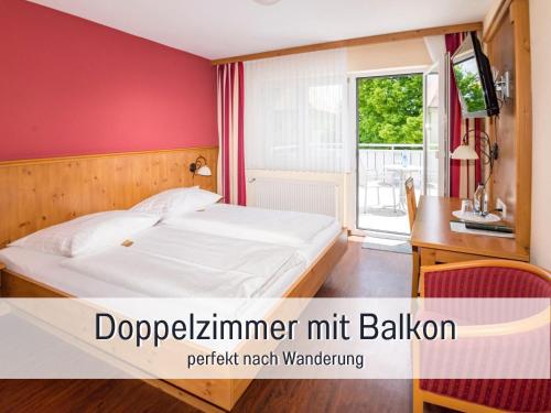 a bedroom with a bed and a desk and a window at Landgasthof Linde - In ruhiger, ländlicher Umgebung in Deggenhausertal