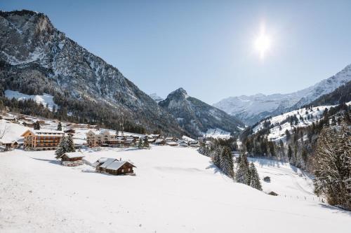 LaVida Peak Mountain Retreat in Frutigen في Wengi bei Frutigen: قرية في الثلج وجبال في الخلف