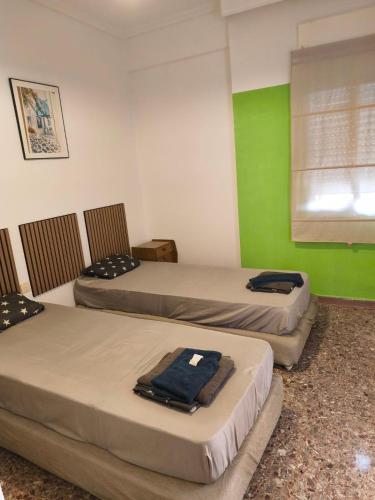 three beds in a room with green walls at Central Michaniona AP in Nea Michaniona