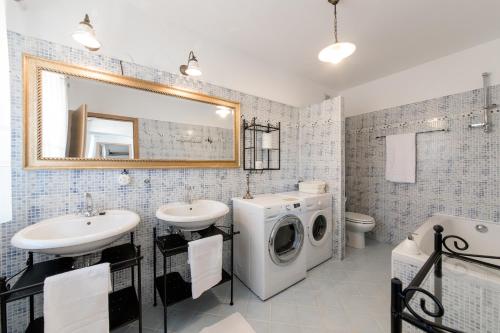 a bathroom with a washing machine and a washer and dryer at Vila Sistiana in Kostanjevica na Krasu