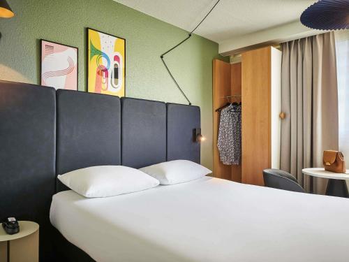 1 cama con 2 almohadas en una habitación en ibis Paris Avenue d'Italie 13ème, en París