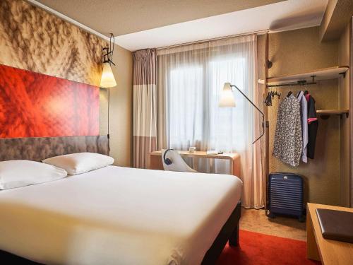 Una habitación de hotel con una cama blanca y una ventana. en ibis Paris Avenue d'Italie 13ème, en París