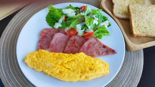 他朗Leamsai Whisper Home的一盘早餐，有肉、鸡蛋和面包。