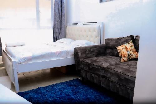 内罗毕Lunic Studio BNB的一间带床和沙发的小卧室