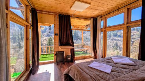 a bedroom with a bed in a room with windows at Monkstel Cottages Shangarh in Shangarh