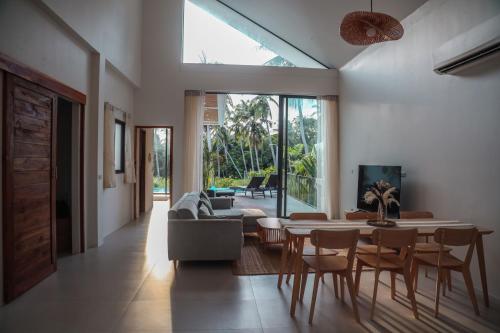 een woonkamer met een tafel en stoelen bij Chic Koh Phangan Villa with Pool Bliss in Ko Phangan