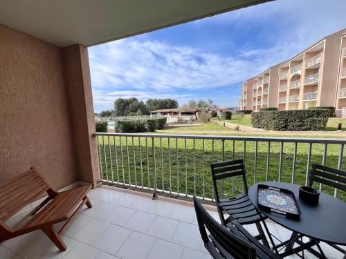 a balcony with a table and chairs and a view at L'Eden - T2 climatisé piscine renové in Balaruc-les-Bains