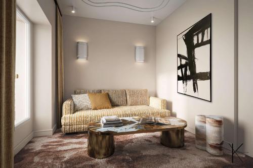 パリにあるJills Hôtelのソファとコーヒーテーブルのあるリビングルーム