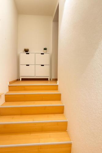 a staircase with wooden floors and a white cabinet at Gemütliches Wohnen in St Leon in Sankt Leon-Rot