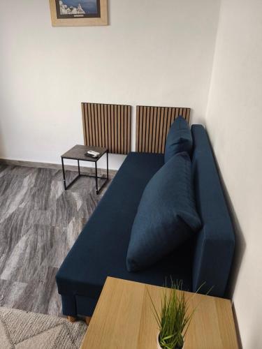 a blue couch in a living room with a table at Michaniona apartment in Nea Michaniona