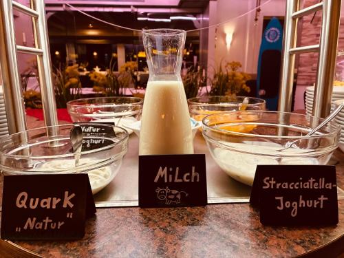 ダゲビュルにあるStrandhotel Dagebüll direkt an der Nordseeの食べ物の入ったボウルと牛乳のボトルが置かれたカウンター
