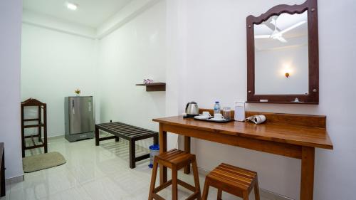 ein Badezimmer mit einem Holztisch und einem Spiegel in der Unterkunft Shady mango villa in Sigiriya