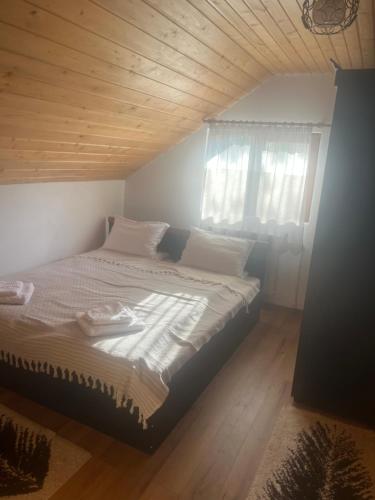 a bed in a bedroom with a wooden ceiling at Cabana Ilinca in Sălciua de Jos