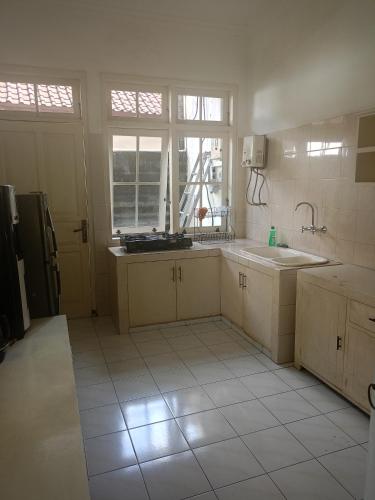 a kitchen with a sink and a refrigerator at Casavina residen kubu manyar 202 in Dalung