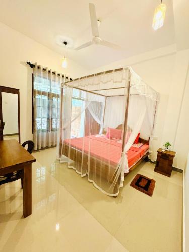 a bedroom with a canopy bed in a room at Nethmi Homestay & family Restaurant in Tangalle