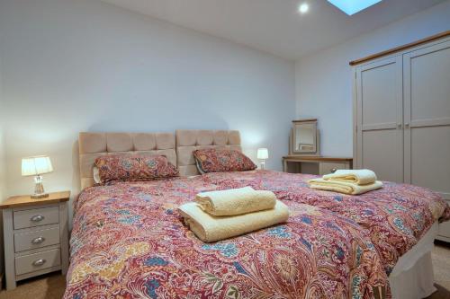 a bedroom with a large bed with two towels on it at Finest Retreats - Courtyard View at Longford in Hollington